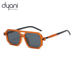 The Prismatik sunglasses with orange sharp-angled frame and dark lenses, perfect for day-to-night transitions and creative spaces.