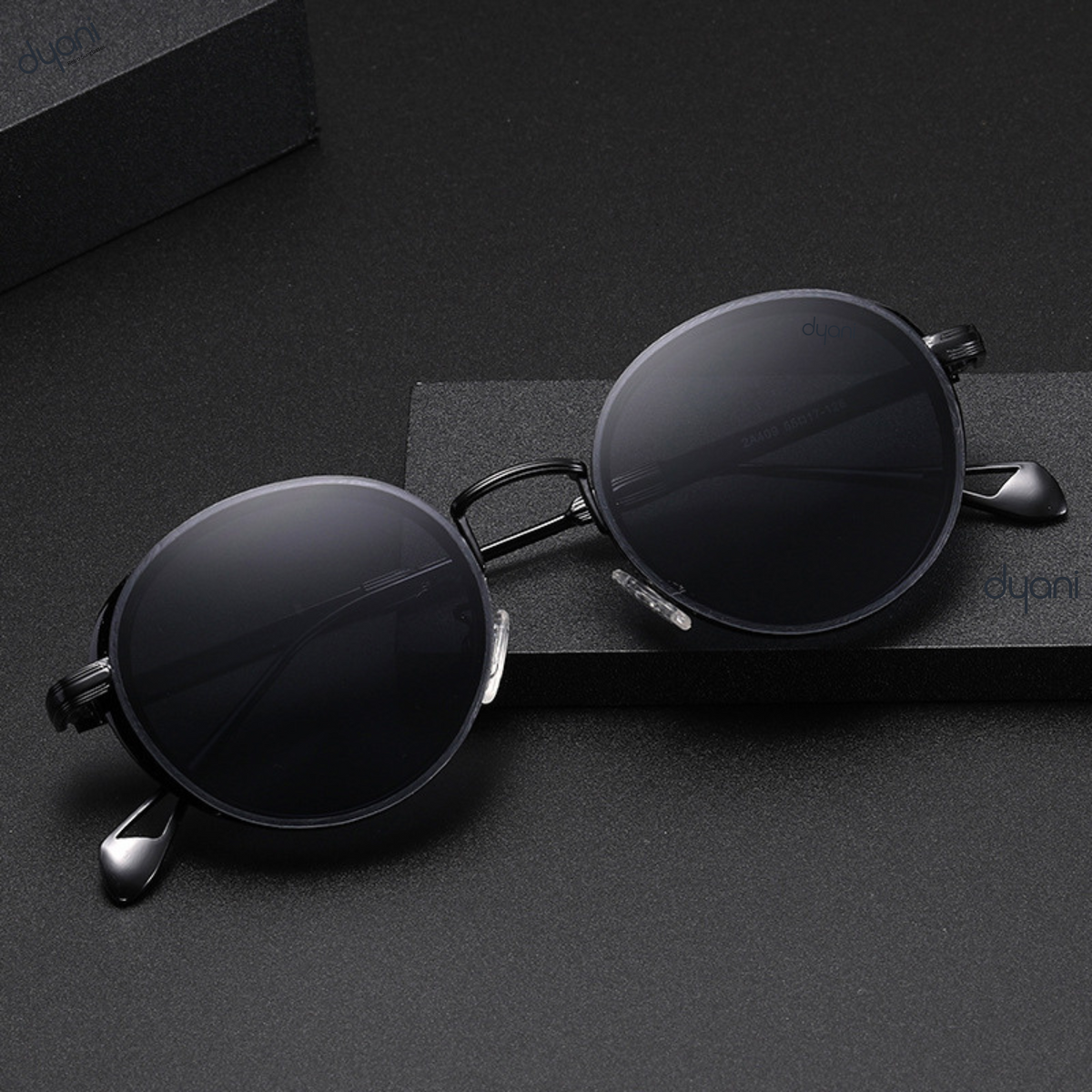 The Luna steampunk inspired round sunglasses with vintage charm on a black surface, blending retro aesthetics and contemporary sophistication.