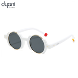 Retro round sunglasses with black and gold gradient lenses, white frame, and red and gold temple tips by Dyani.