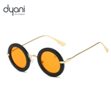 Solaris round-frame sunglasses with orange lenses and metal arms by Dyani, blending vintage style with modern flair.