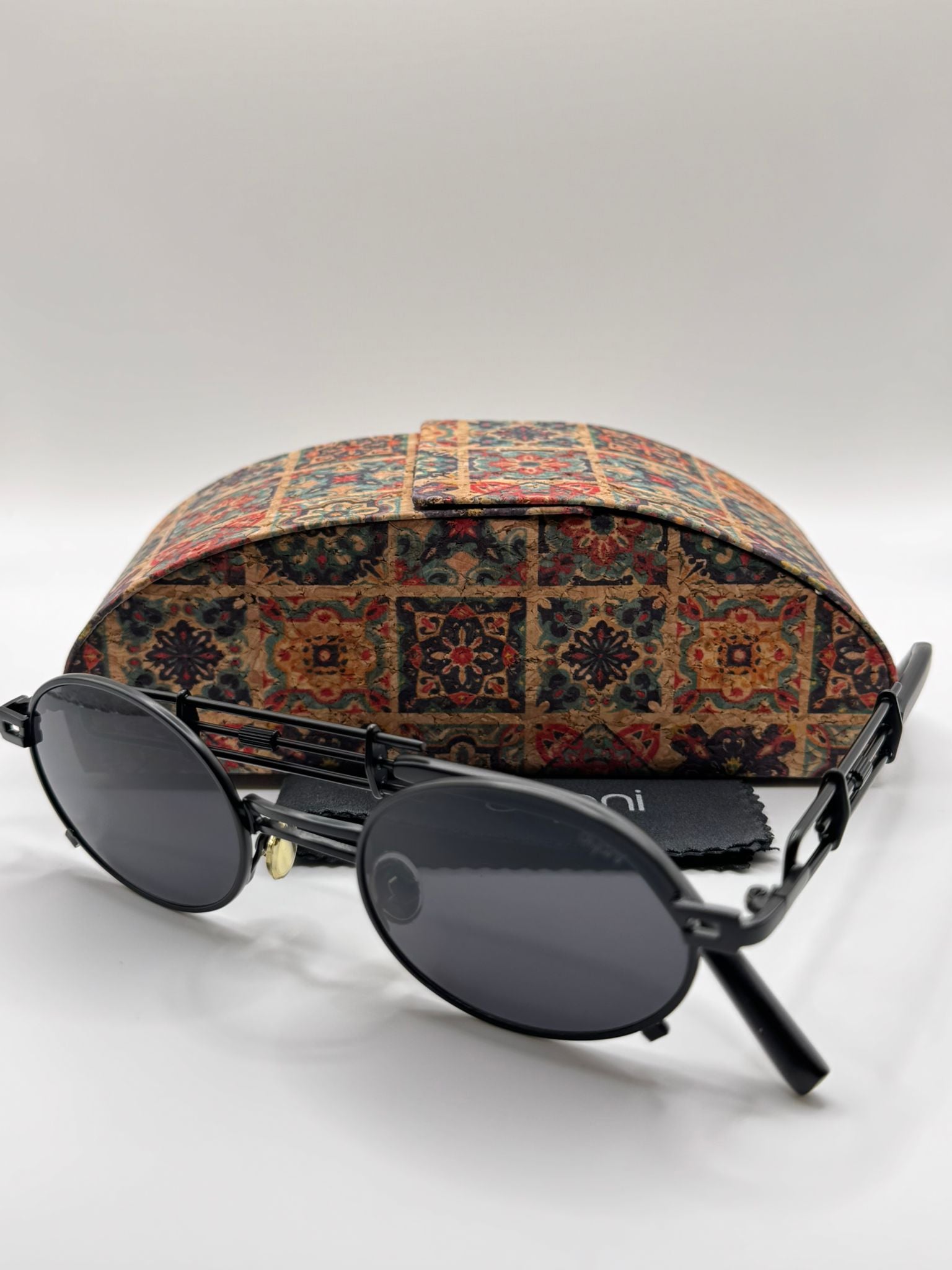 JazzyOval metal frame retro sunglasses with smooth oval lenses and patterned case, showcasing modern flair and funky charm.